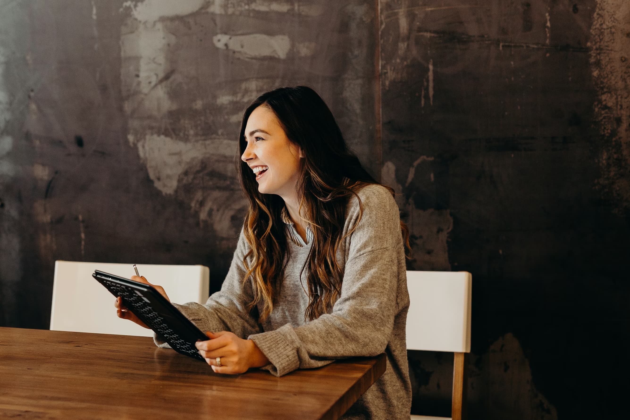 A candidate smiling while writing notes during a conversation